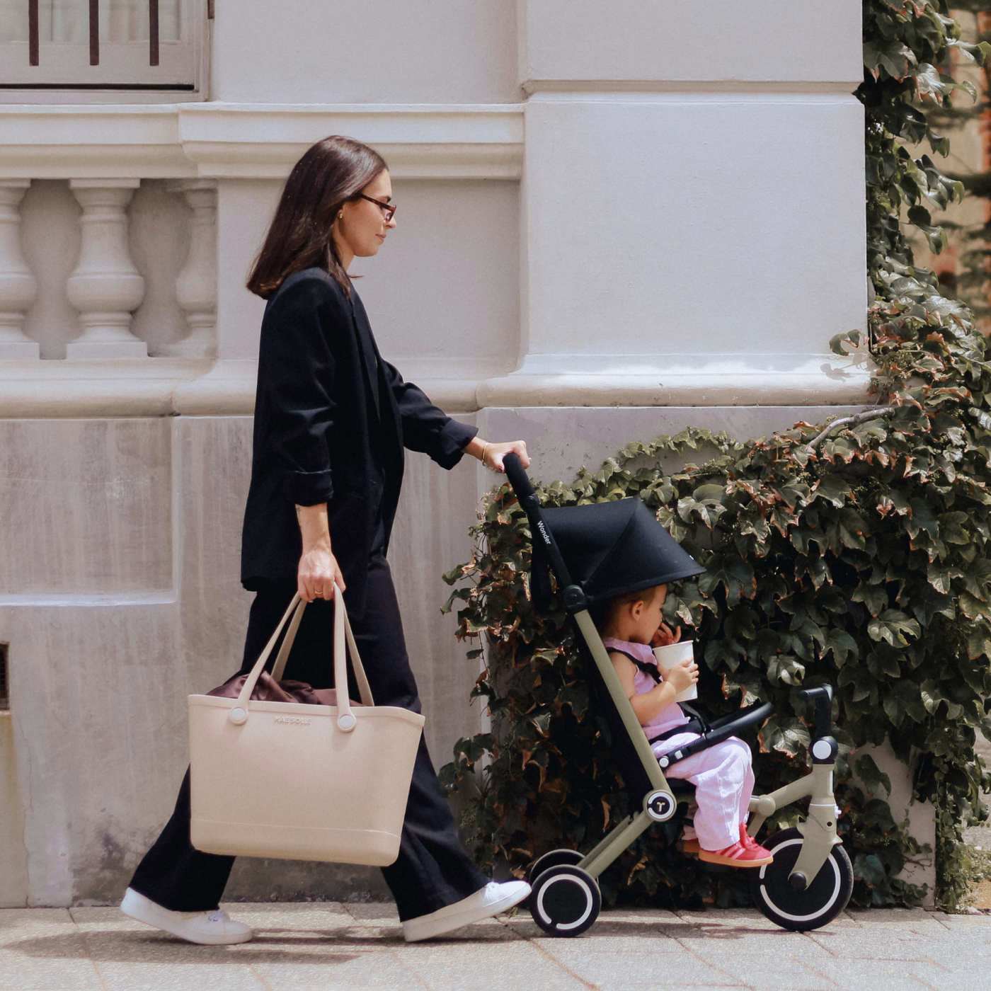 A parent walking with a toddler in a Wonder in stroller mode
