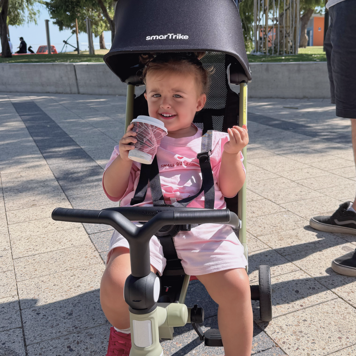 A toddler holding a drink in a Wonder in stroller mode